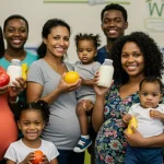 Smiling mothers and children with healthy food at WIC clinic
